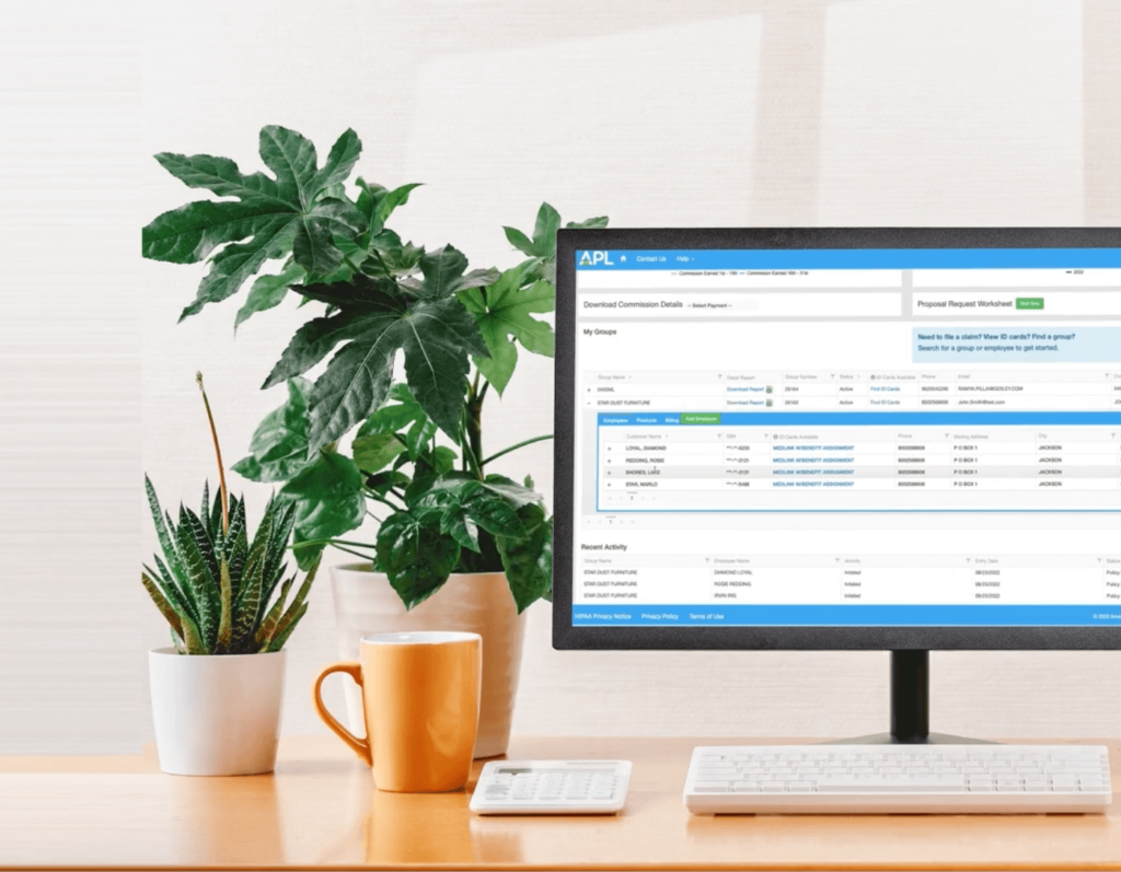 Mockup of a desk with plants, a mug, keyboard, calculator, and a desktop computer. The desktop computer shows a screenshot of a page on APLs site